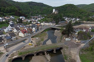 Zerstörte Brücke umgeben von ebenfalls zerstörten Häusern