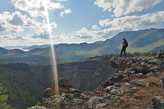 Frau in Wanderkleidung steht im Gebirge