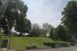 Blick auf den Schulhof mit einer Tischtennisplatte und mehreren Bänken