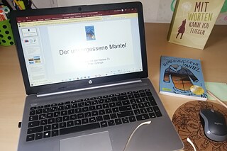 Aufgeklappter Laptop auf einem Schreibtisch