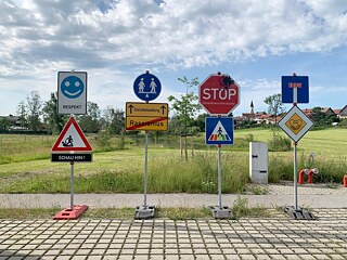 Verkehrsschilder der Gerechtigkeit vor grüner Landschaft